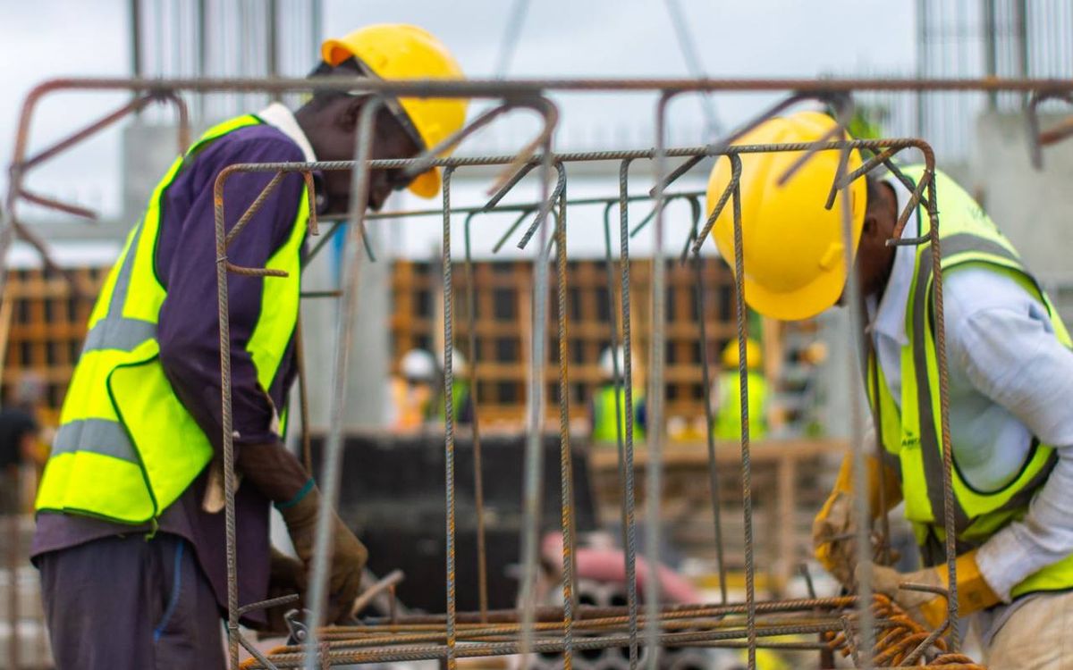 Workers in yellow hard hats and high-visibility vests on a construction site